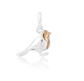 A sterling silver charm shaped like a robin bird with a rose gold breast.